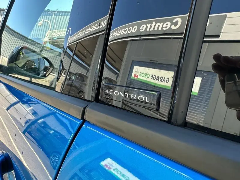 Détail sur la porte côté gauche d'une Renault Rafale bleu sommet métallisé avec badge 4Control et rétroviseur.