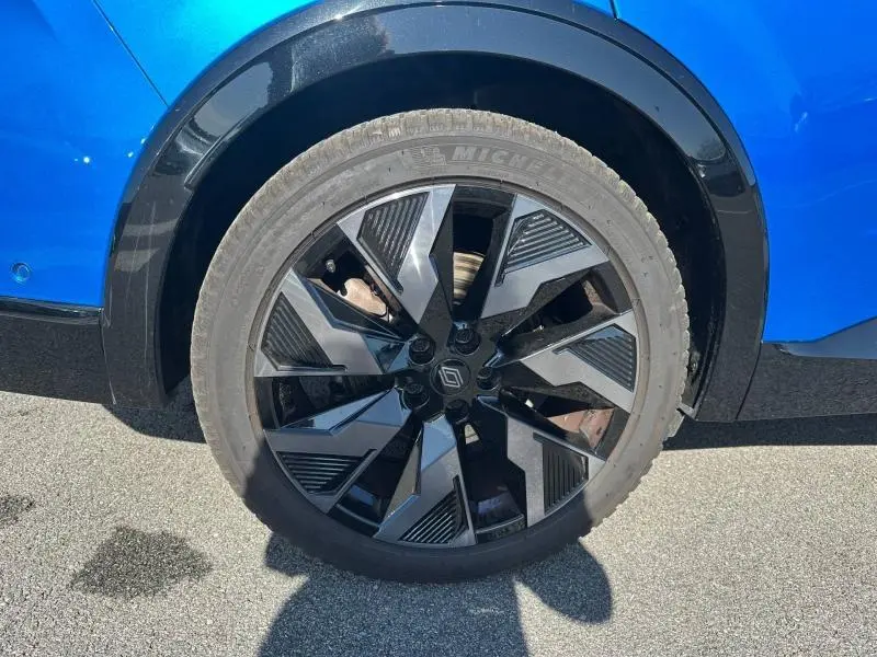 Gros plan sur la roue arrière droite du Renault Rafale bleu sommet métallisé avec jante alu noire au design géométrique.