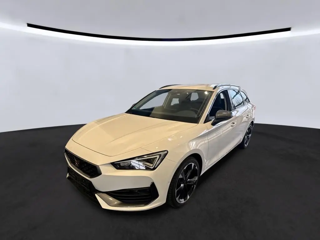 Vue 3/4 avant droite d'une CUPRA Leon ST blanche 2024 avec jantes noires et toit ouvrant.