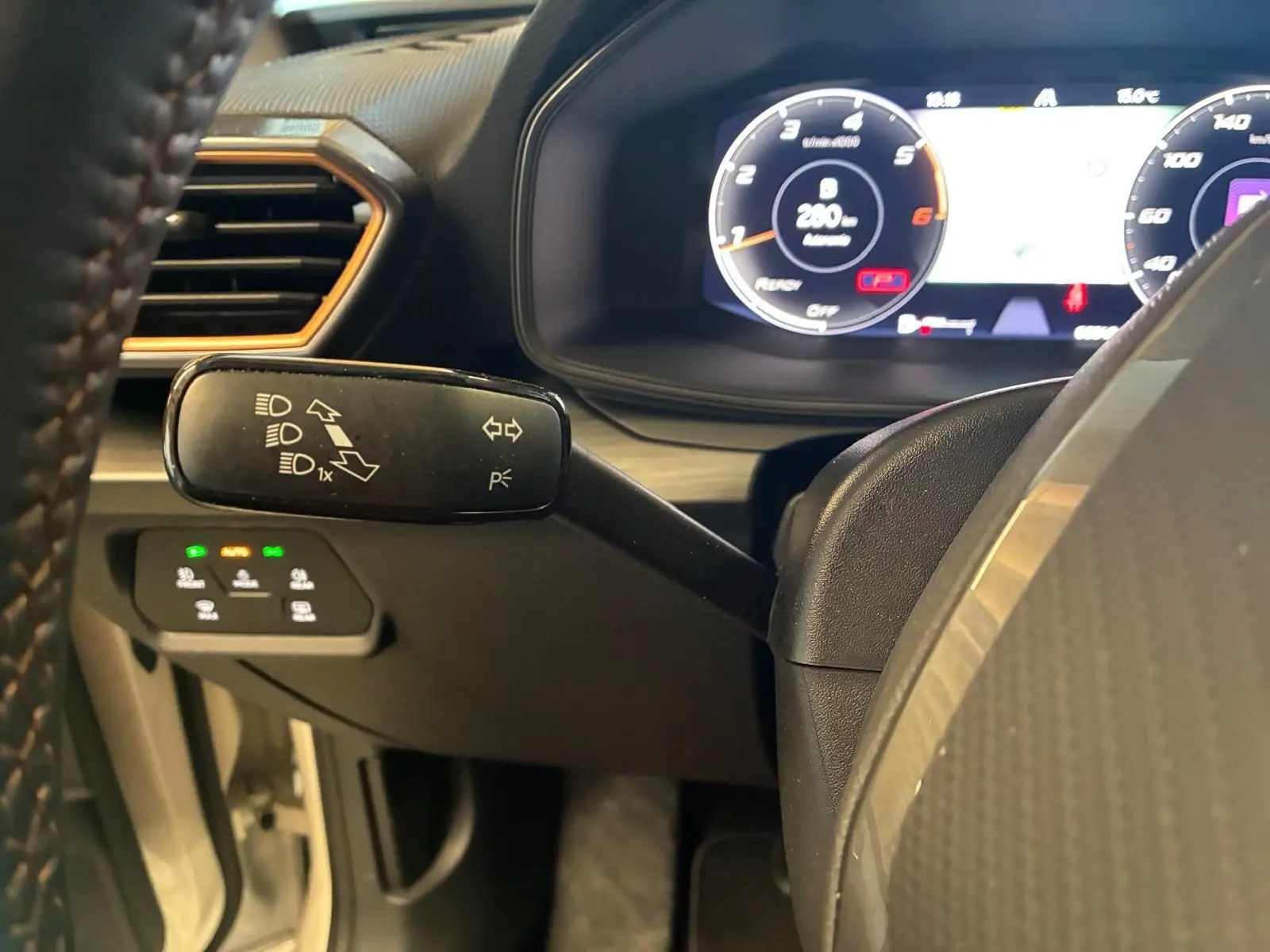 Gros plan sur la manette de clignotants à gauche du volant dans l’habitacle noir du CUPRA LEON ST 2024.