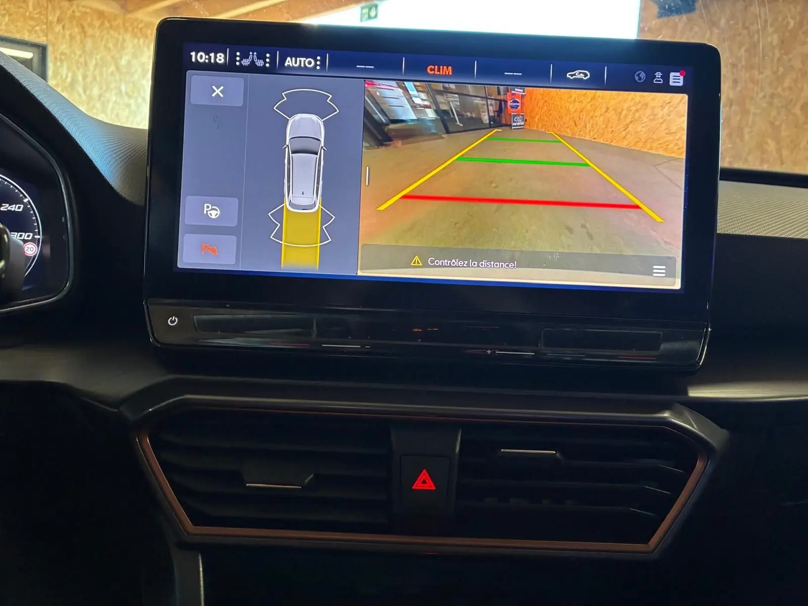 Écran central de la CUPRA LEON ST blanc 2024 montrant la caméra de recul avec lignes de guidage colorées.