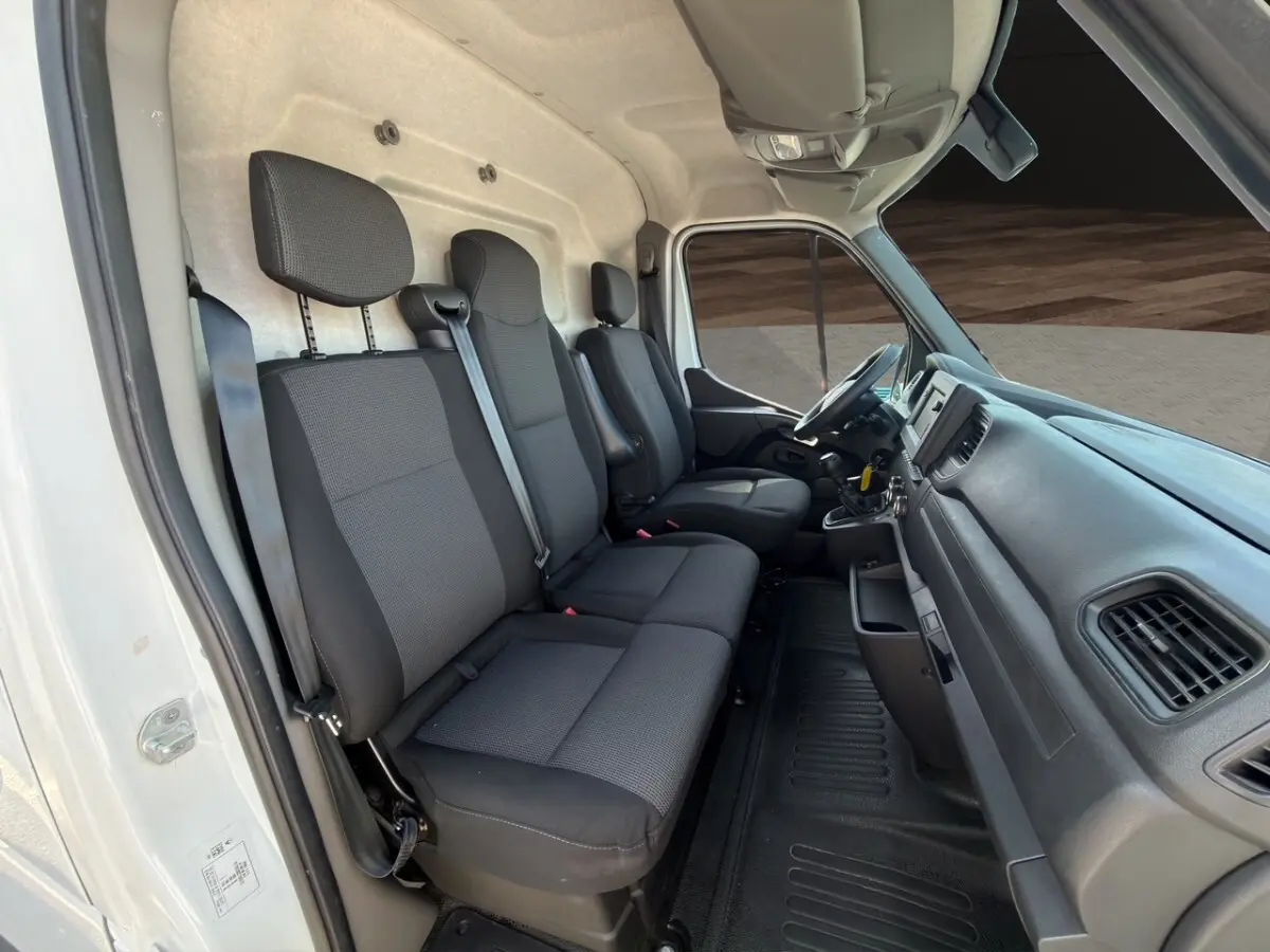 Intérieur cabine Renault Master 2023 vu côté gauche, sièges tissu noirs et tableau de bord fonctionnel.