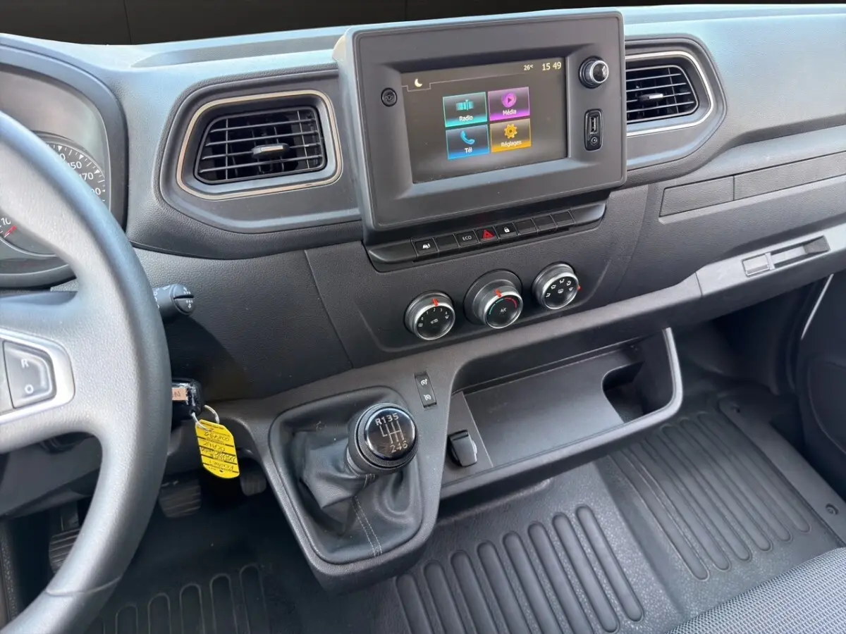 Vue intérieure du tableau de bord du Renault Master 2023, avec écran tactile central et levier de vitesse manuel.