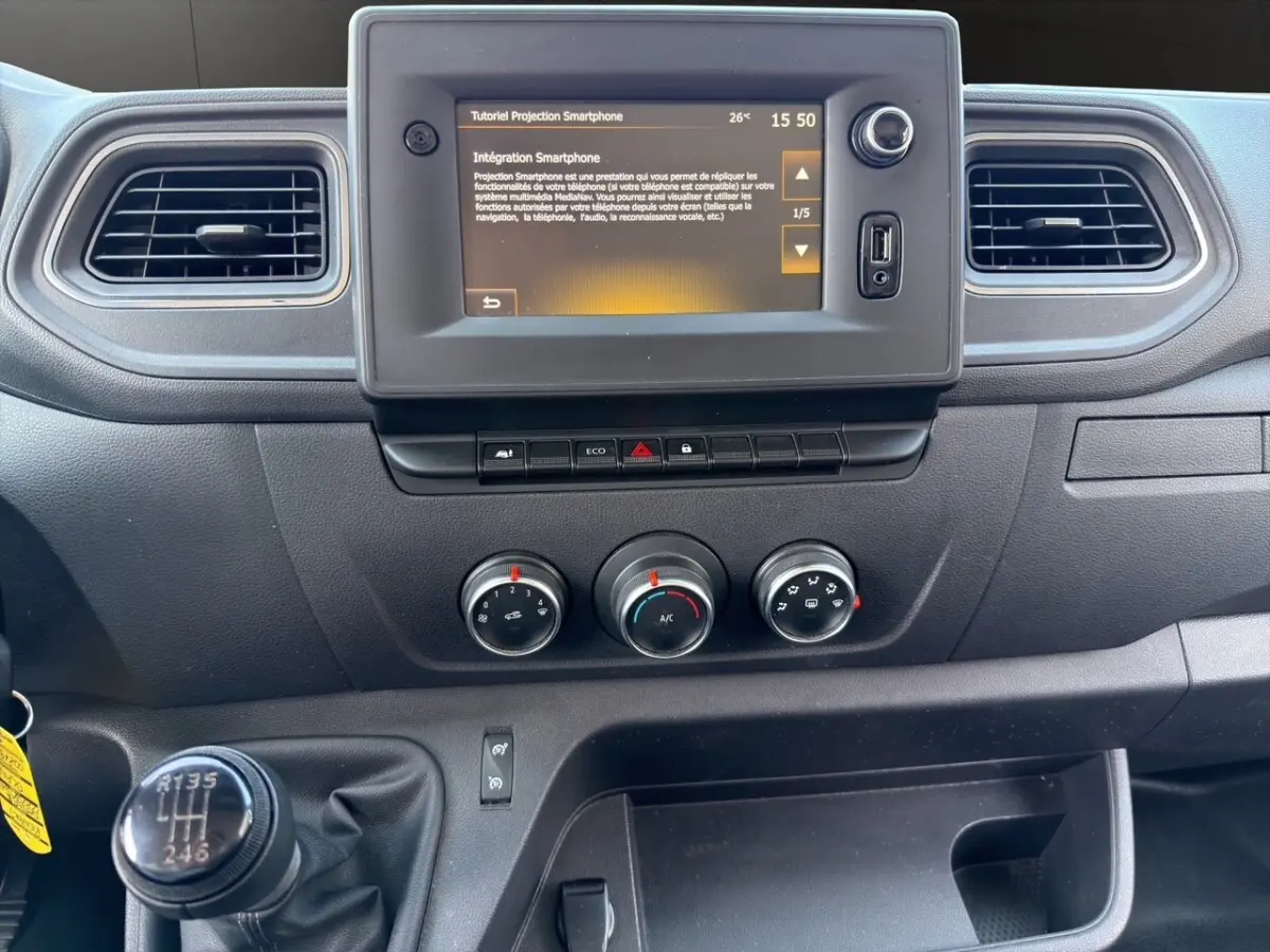Vue rapprochée du tableau de bord noir du Renault Master 2023 avec écran tactile et levier de vitesse manuel.