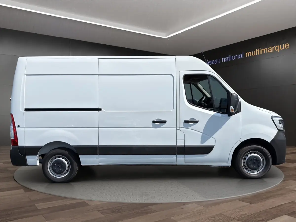 Vue latérale droite d’un Renault Master blanc utilitaire avec cloison pleine et jantes acier noires.