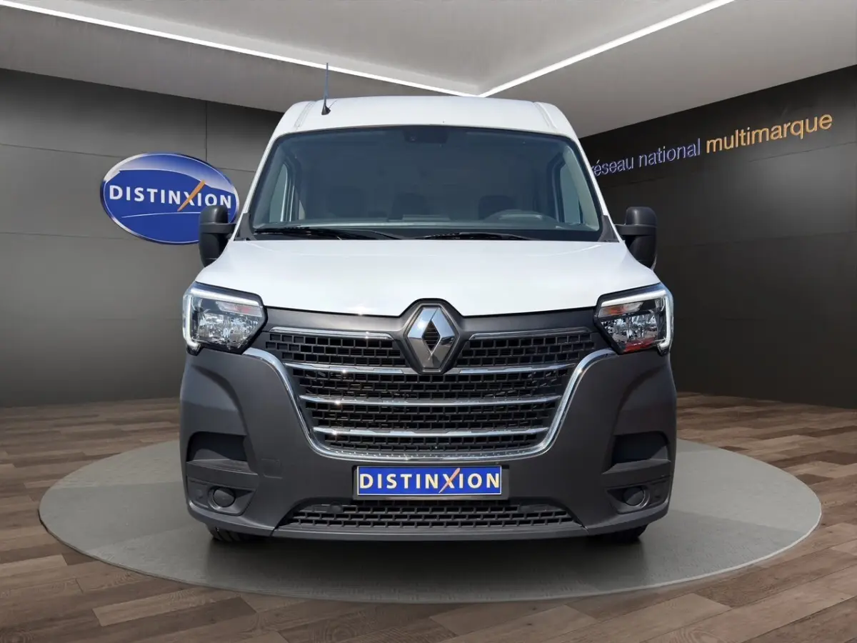 Vue frontale d’un Renault Master blanc avec pare-chocs noir et logo Renault bien visible, en showroom.