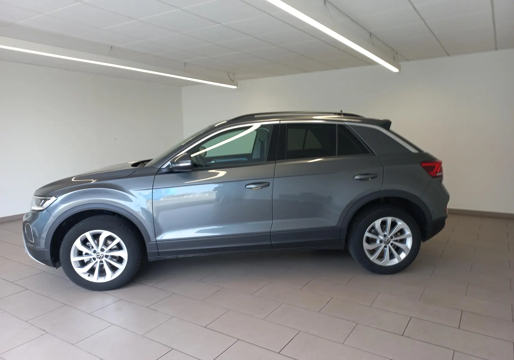 Volkswagen T-Roc 1.5 TSI 150 DSG7 VW Edition gris Indium vu de profil côté gauche en intérieur.