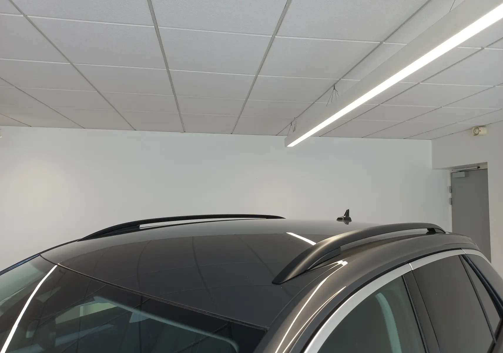 Vue rapprochée du toit gris indium du Volkswagen T-Roc 2025, avec barres de toit noires et antenne requin.