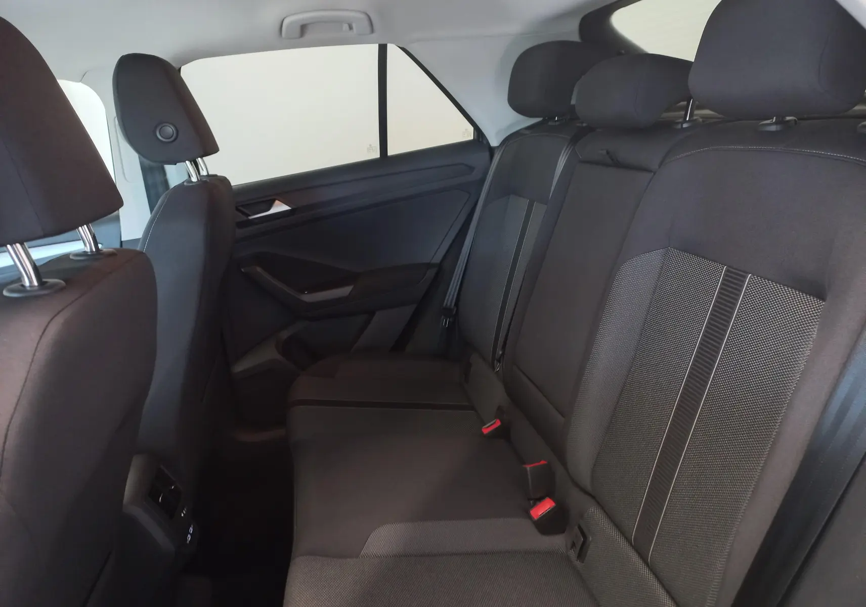 Vue intérieure côté droit des sièges arrière noirs du Volkswagen T-Roc 1.5 TSI 150 DSG7 VW EDITION 2025 en gris Indium.