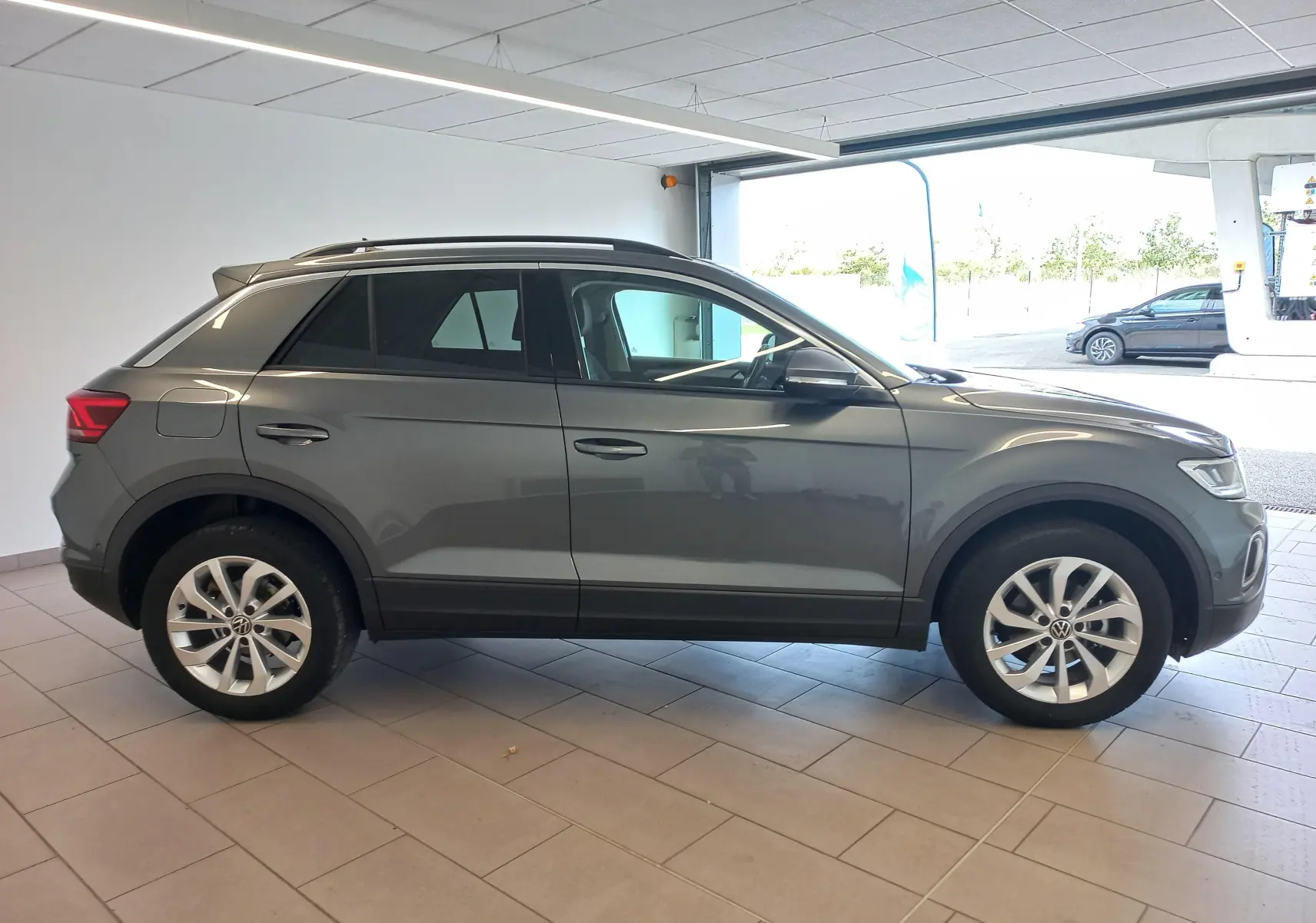 Volkswagen T-Roc 1.5 TSI 150 DSG7 VW Edition gris Indium vu de profil côté gauche en intérieur showroom.