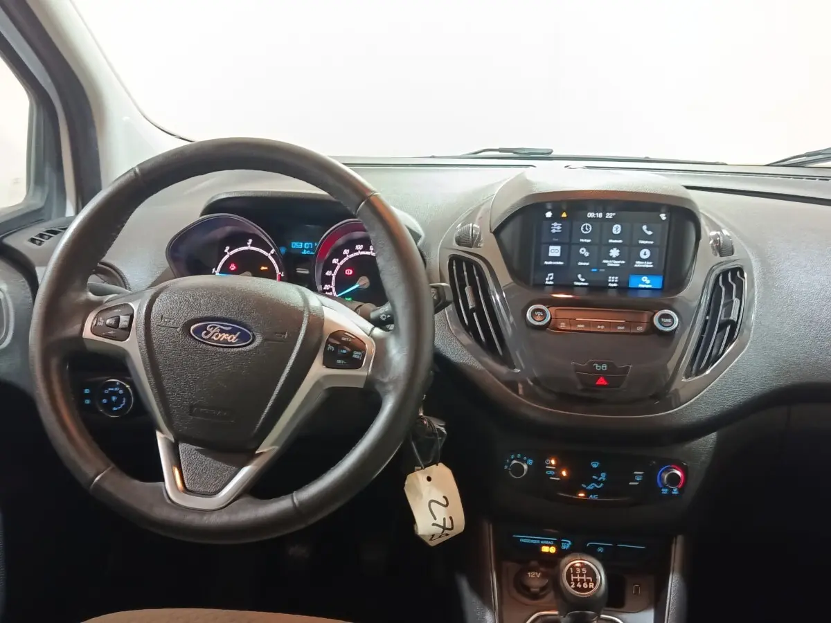 Vue intérieure centrée sur le volant cuir multifonctions et le tableau de bord numérique du Ford Grand Tourneo Connect blanc.