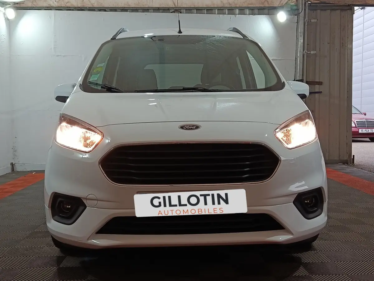 Vue frontale d'un Ford Grand Tourneo Connect blanc de 2020 avec phares allumés et calandre noire.