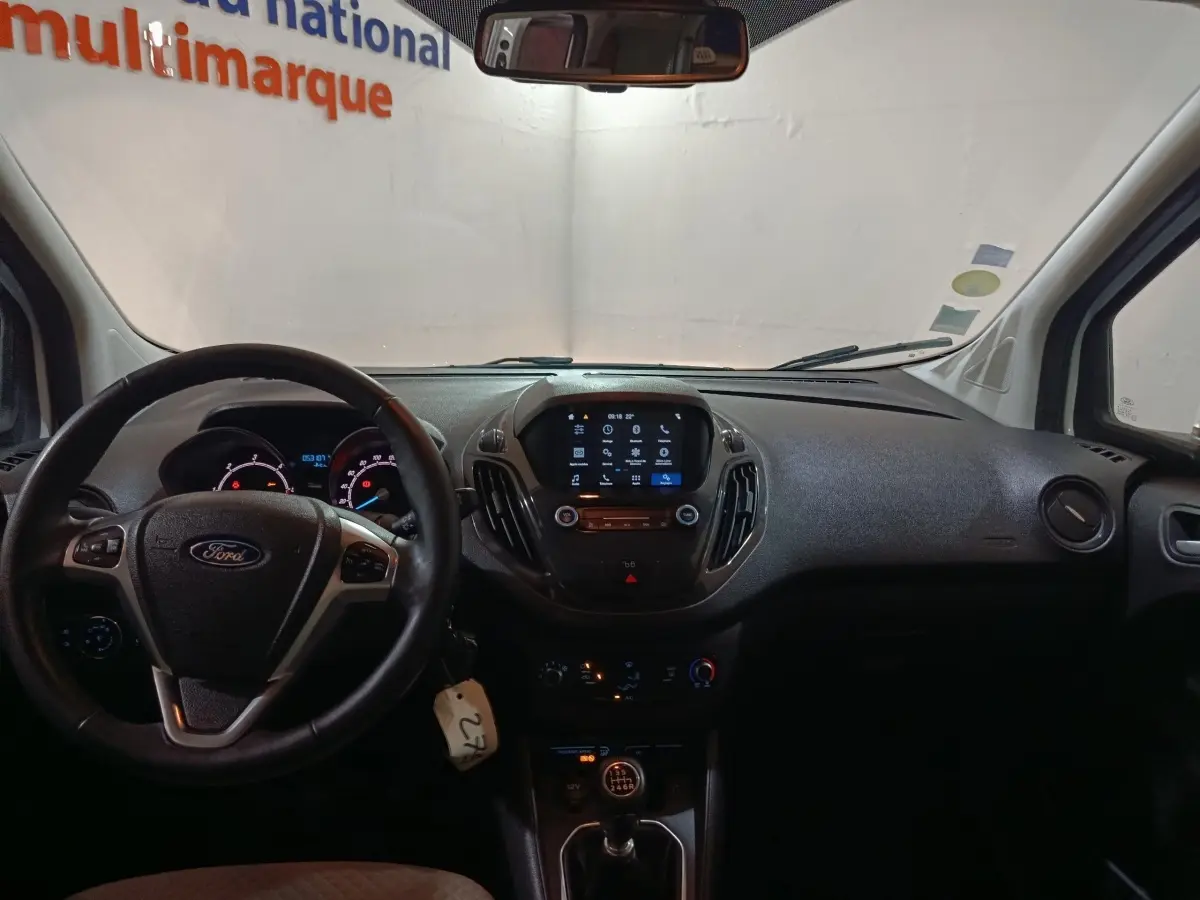 Vue intérieure du tableau de bord noir du Ford Grand Tourneo Connect 2020, avec volant cuir et écran tactile central allumé.