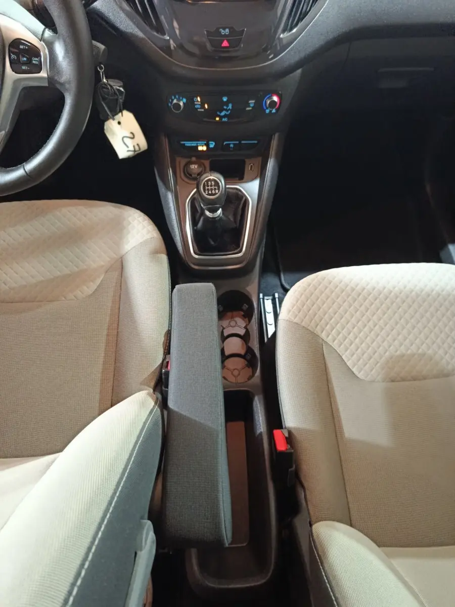 Vue intérieure centrée sur la console centrale et levier de vitesse manuel du Ford Grand Tourneo Connect 2020, sièges beige.