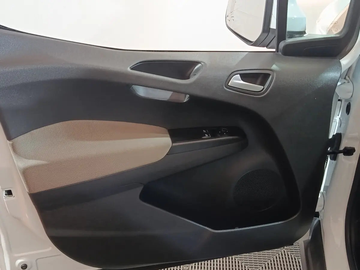 Vue intérieure de la porte avant gauche blanche du Ford Grand Tourneo Connect avec panneau noir et beige et commandes électriques.