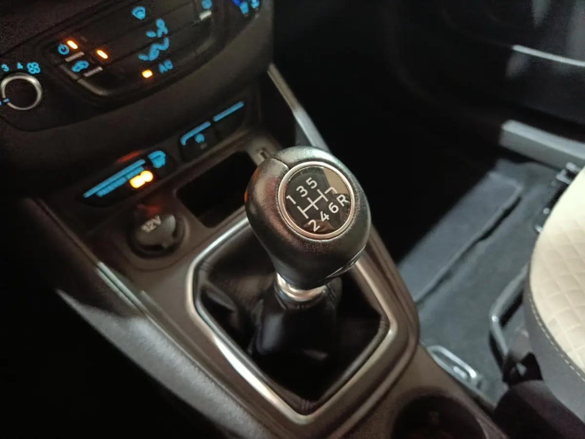 Gros plan sur le levier de vitesses manuel noir du Ford Grand Tourneo Connect 2020, entouré de commandes et prise 12V.