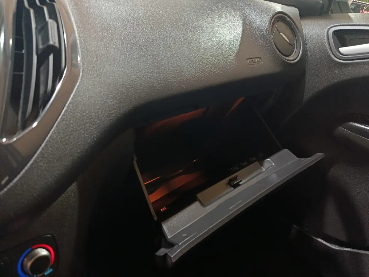 Gros plan intérieur sur la boîte à gants ouverte du Ford Grand Tourneo Connect blanc, côté passager.