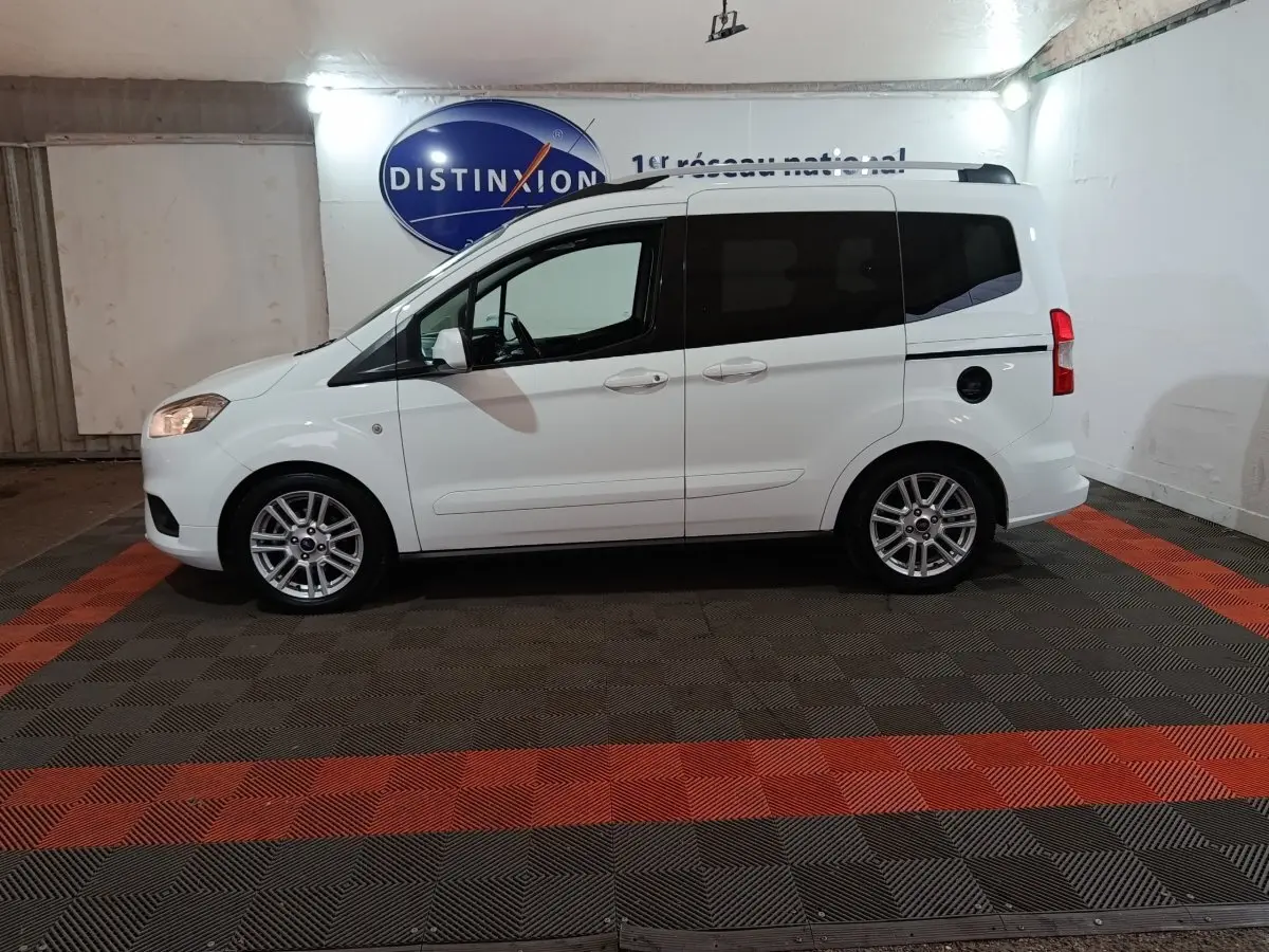 Vue de profil côté gauche d'un Ford Grand Tourneo Connect blanc 2020 avec vitres arrière teintées et jantes alliage.