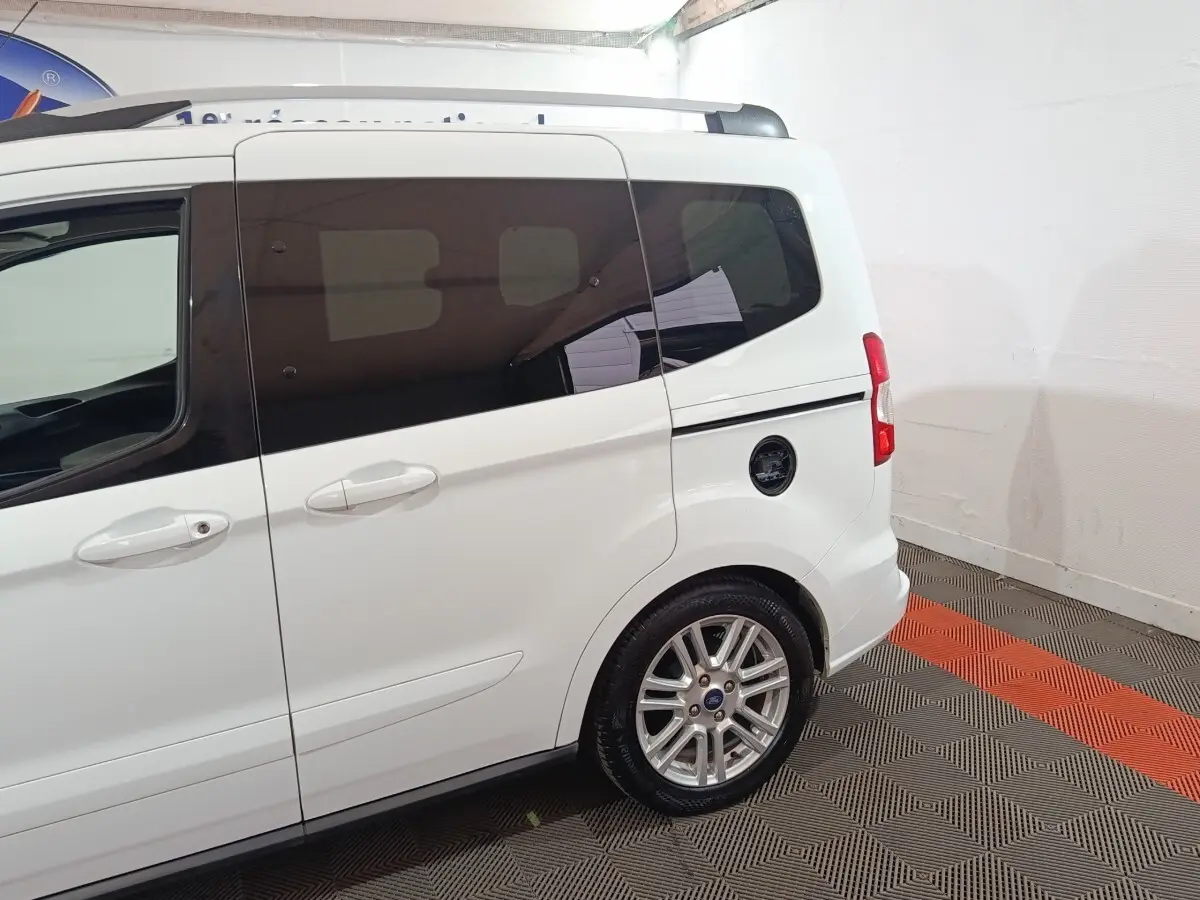Vue latérale arrière droite d’un Ford Grand Tourneo Connect blanc avec vitres teintées et jantes alliage.