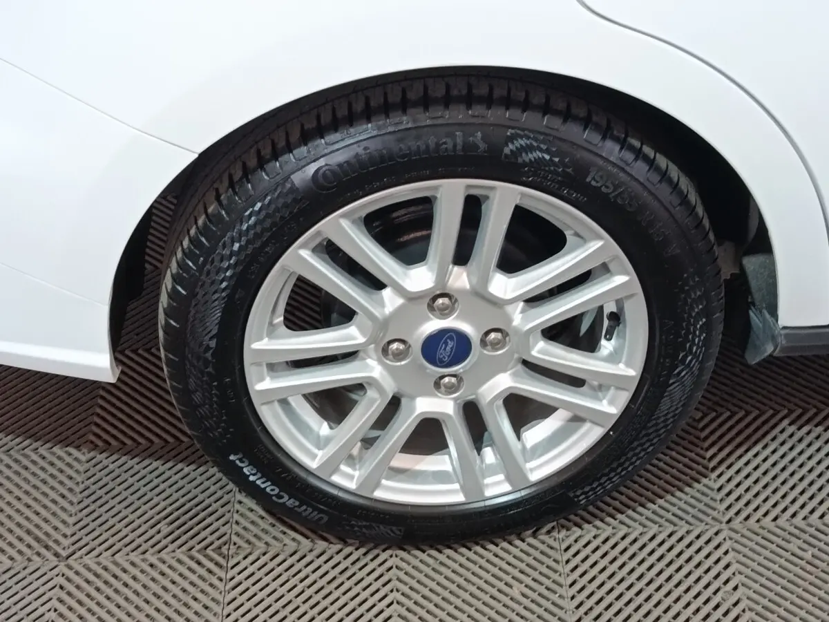 Gros plan sur la roue avant droite du Ford Grand Tourneo Connect blanc, avec jante alliage et pneu Continental.