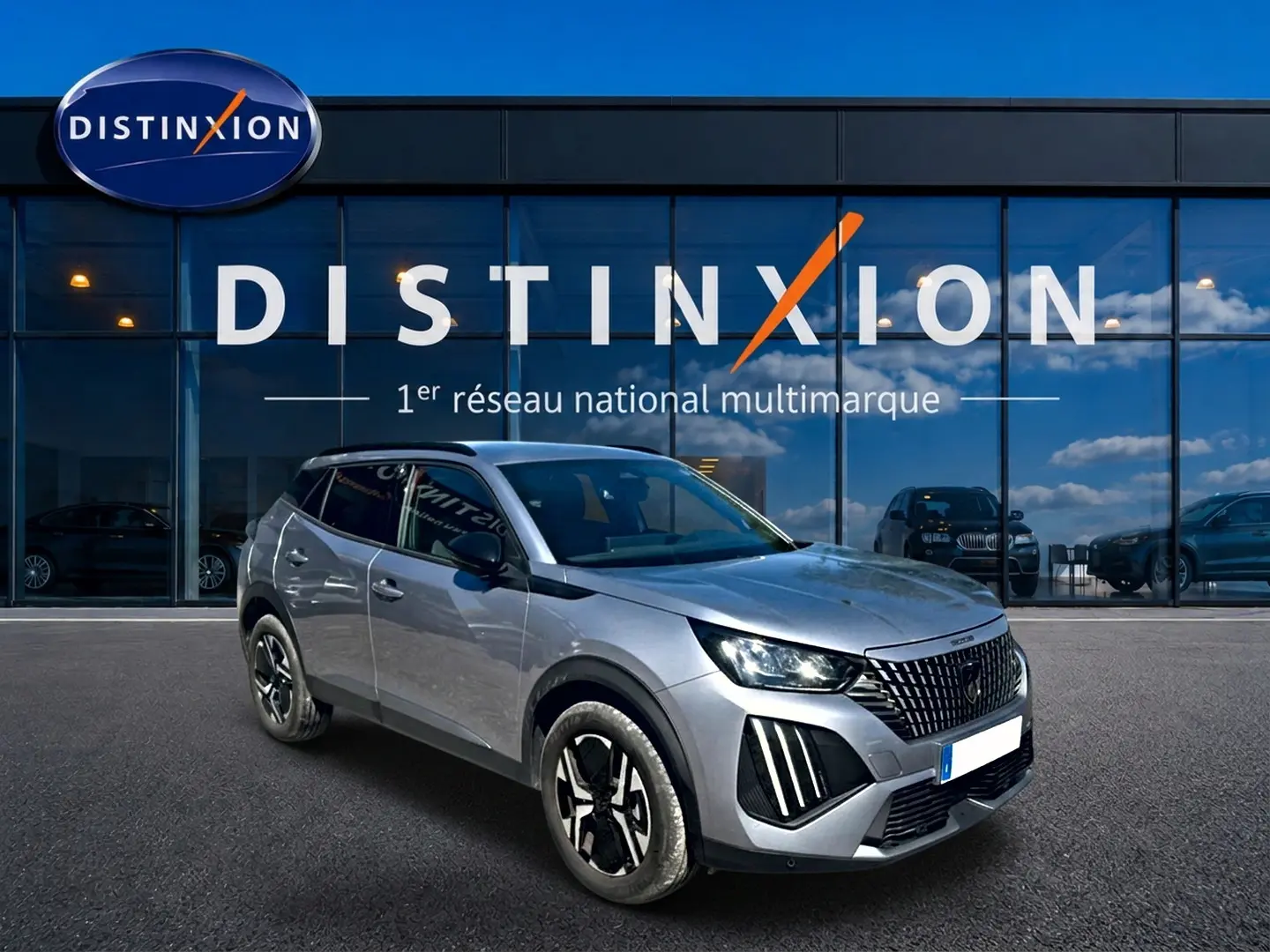 Peugeot 2008 gris artense en 3/4 avant droit, avec calandre verticale et jantes alliage noires et argentées.