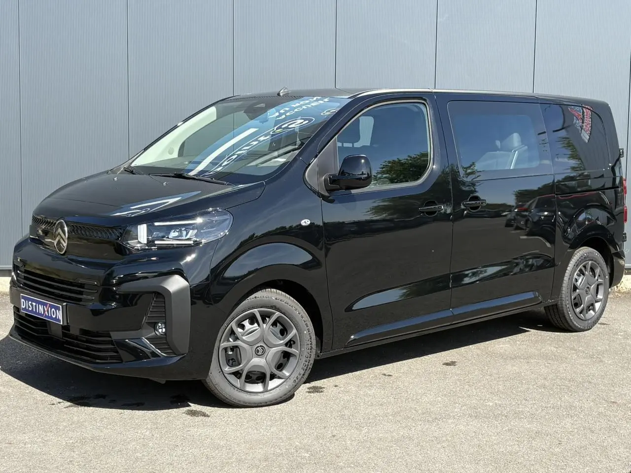 Vue 3/4 avant droite du Citroën Jumpy noir Perla avec jantes tôle noires et porte latérale coulissante visible.