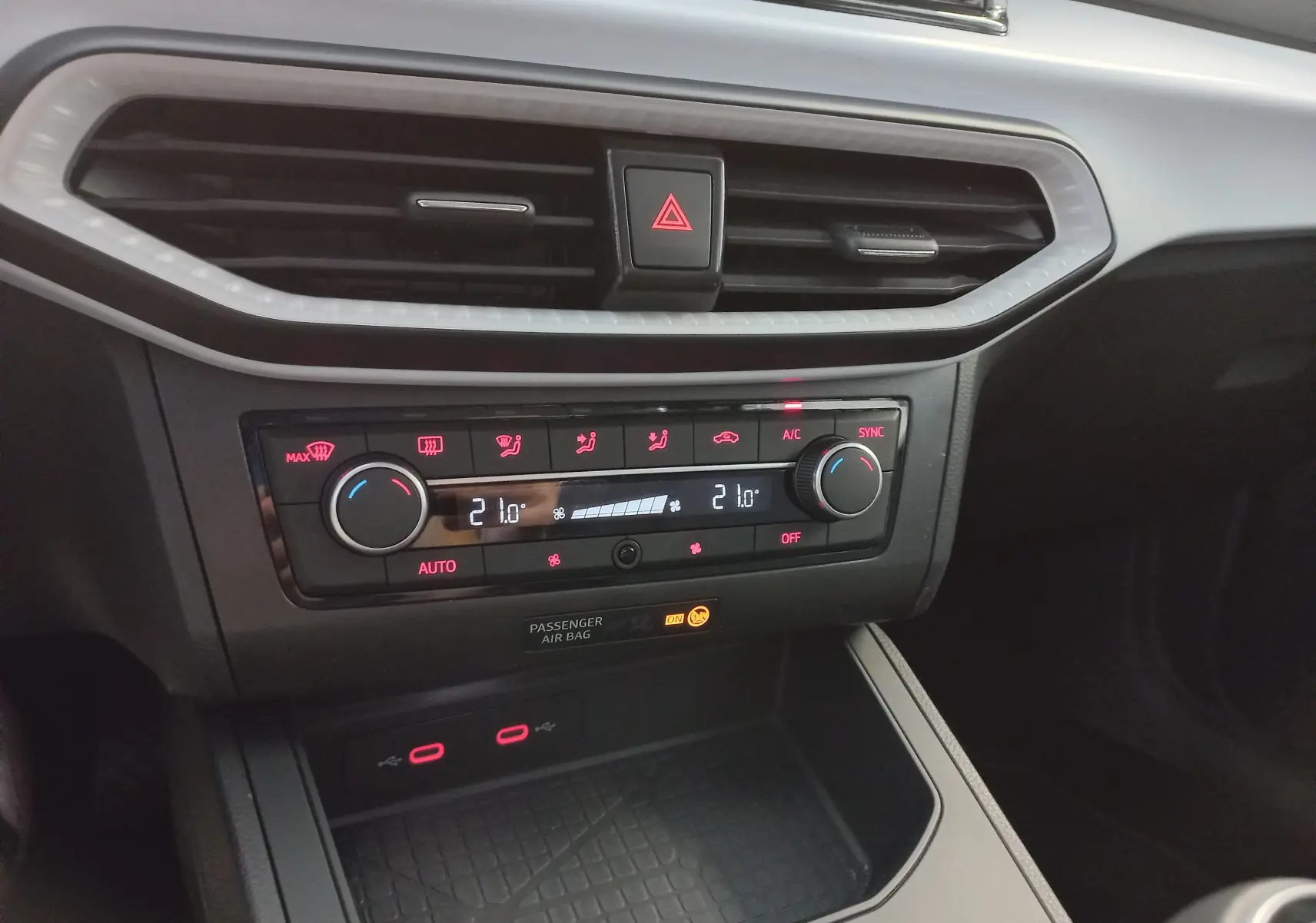 Détail de la console centrale de la SEAT Ibiza 2025 avec commandes climatisation et prises USB éclairées.