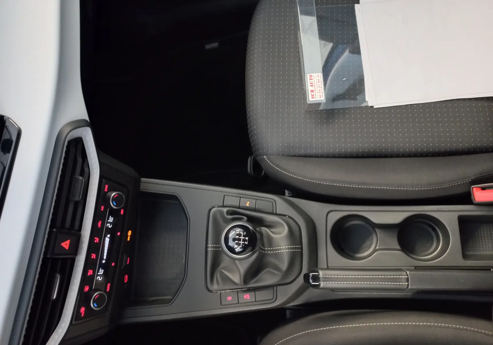 Vue intérieure centrée sur la console centrale de la SEAT Ibiza 2025 bleu saphir, avec levier de vitesse manuel et sièges gris.