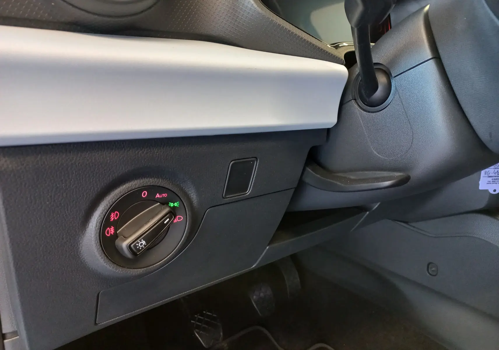 Gros plan sur le sélecteur d'éclairage côté gauche du tableau de bord d'une SEAT Ibiza bleu saphir 2025.