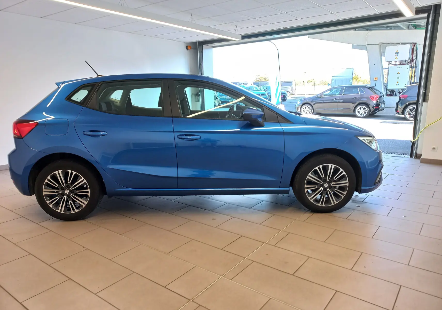 SEAT Ibiza 2025 bleu saphir vue de profil côté gauche en intérieur, avec jantes alliage distinctives.