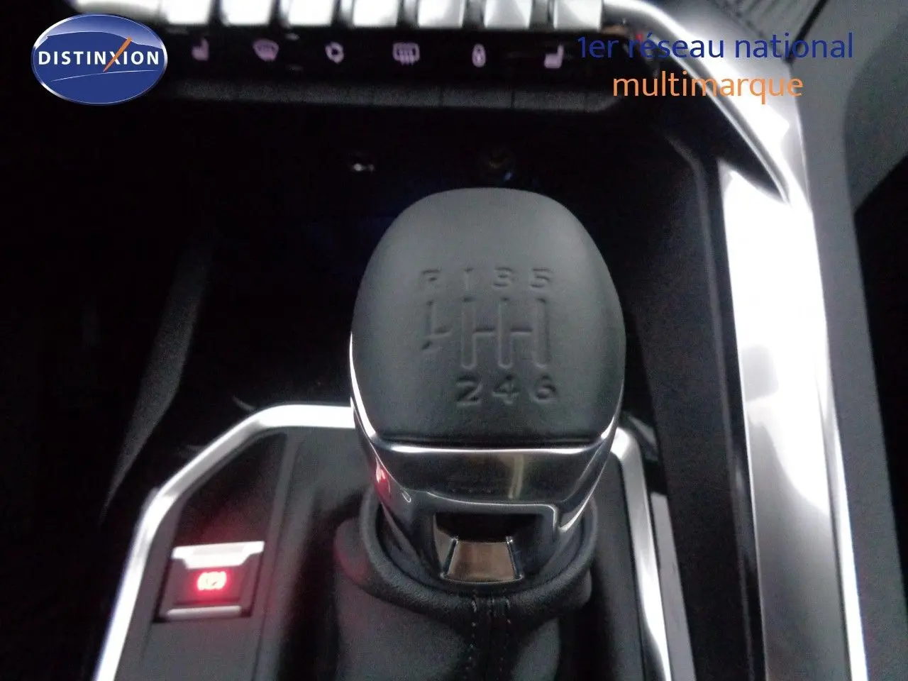 Gros plan sur le levier de vitesse manuel noir du Peugeot 3008 2023, entouré de finitions chromées et commandes éclairées.