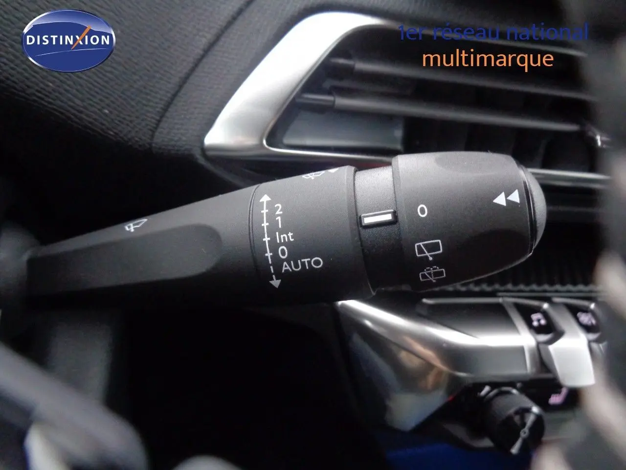 Gros plan sur la commande d’essuie-glace à gauche du volant dans l’habitacle noir du Peugeot 3008 noir perle metal 2023.