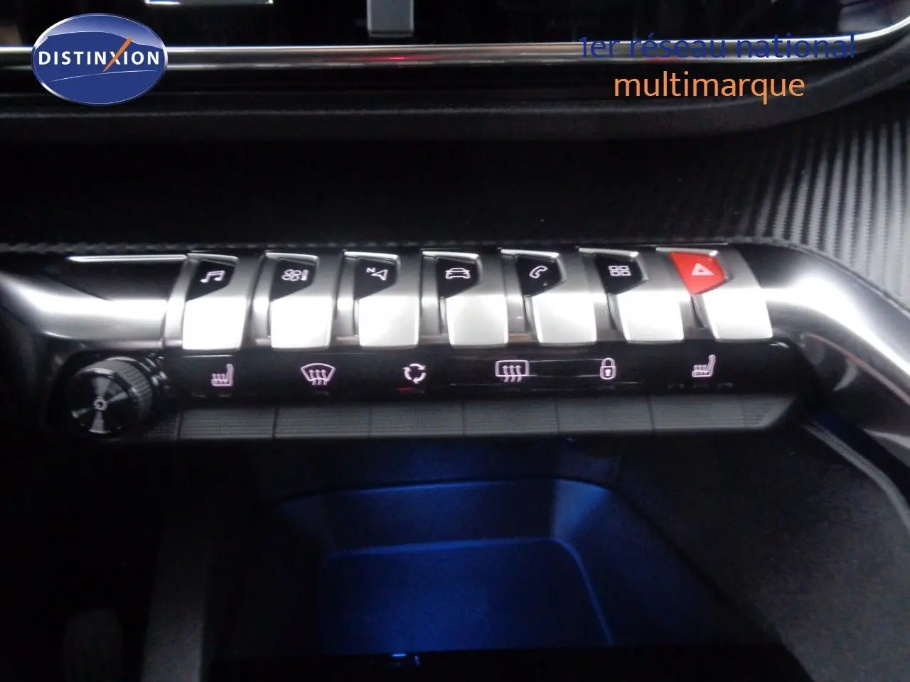 Gros plan sur la rangée de boutons argentés du tableau de bord du Peugeot 3008 noir perle, avec éclairage bleu dessous.