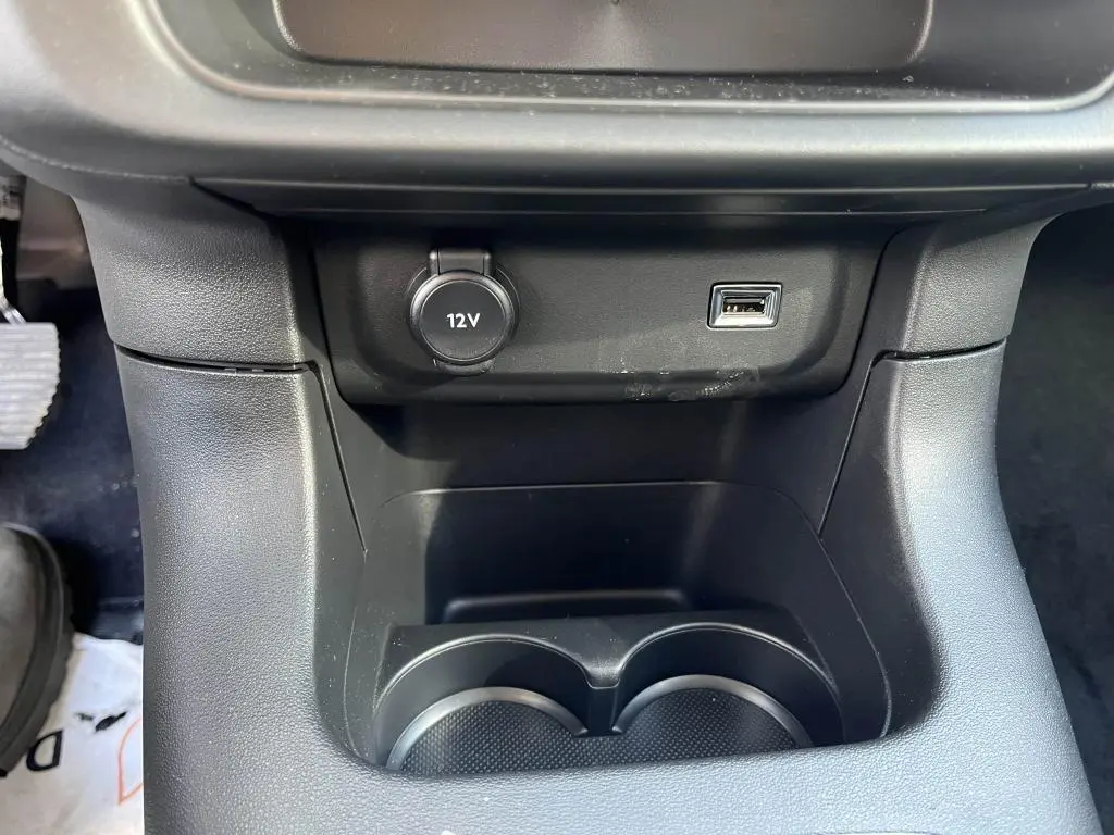 Gros plan sur la console centrale noire de la Citroën C3 2022 avec prise 12V et port USB visible.