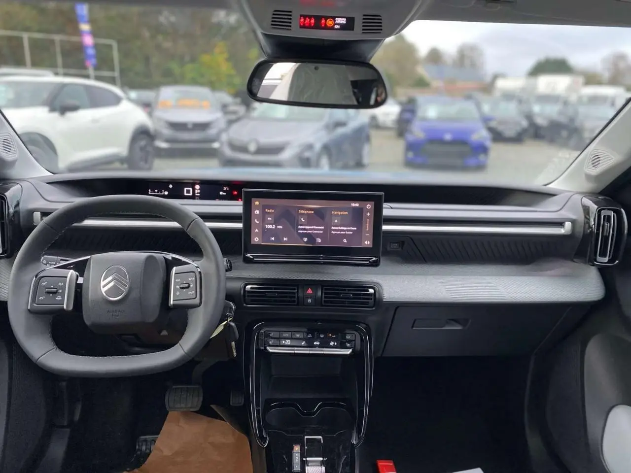 Intérieur du Citroën C3 Aircross 2025 vu de face, tableau de bord moderne avec écran tactile central et volant multifonctions.
