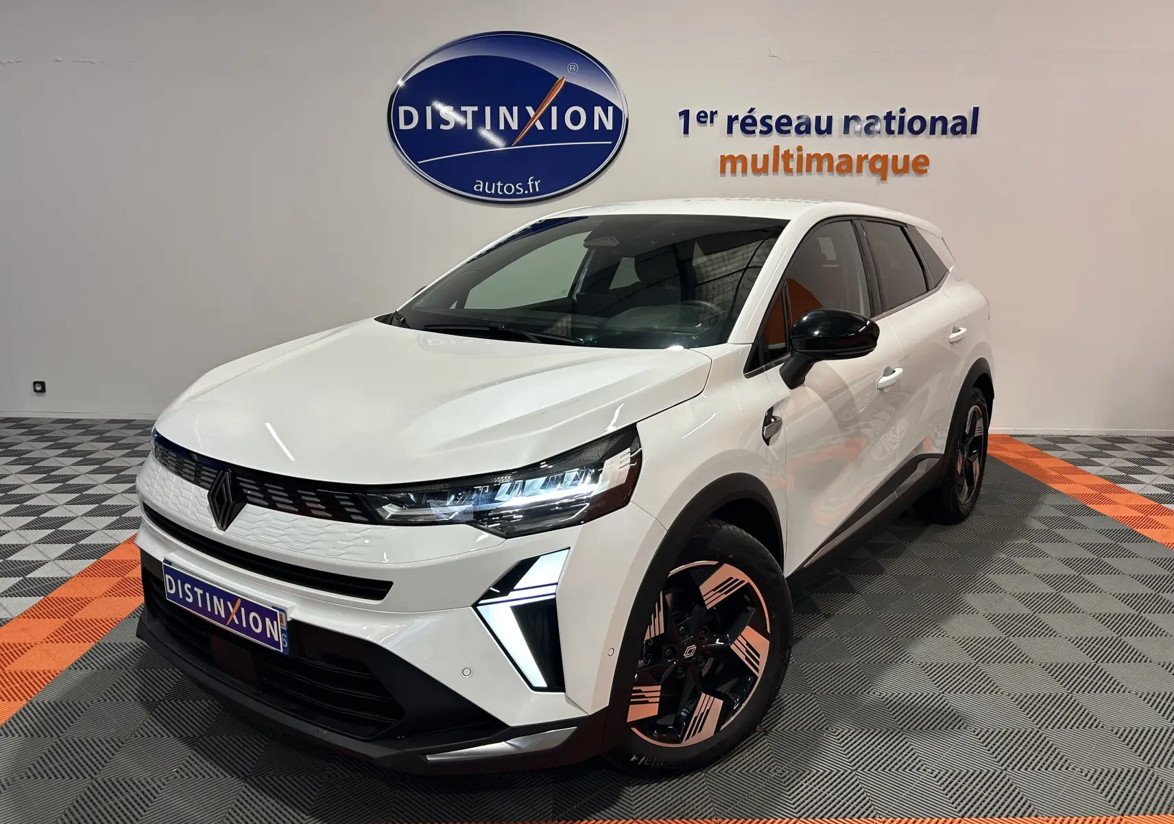 Renault Symbioz blanc nacré en 3/4 avant droit, avec feux LED distinctifs et jantes bicolores stylisées.