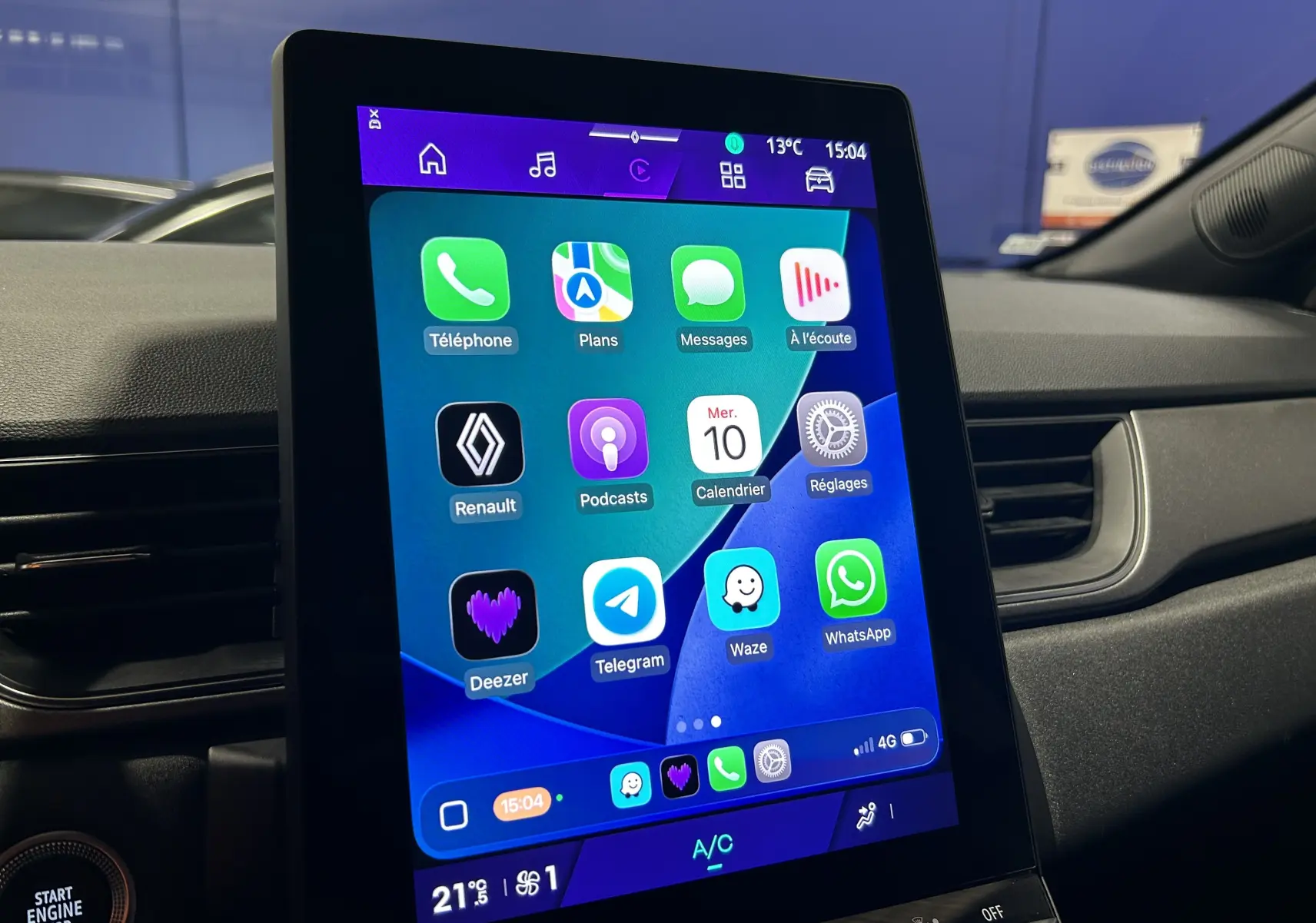 Écran tactile central affichant des applications connectées dans l'habitacle d'une Renault Symbioz blanc nacré, vue de profil droit.