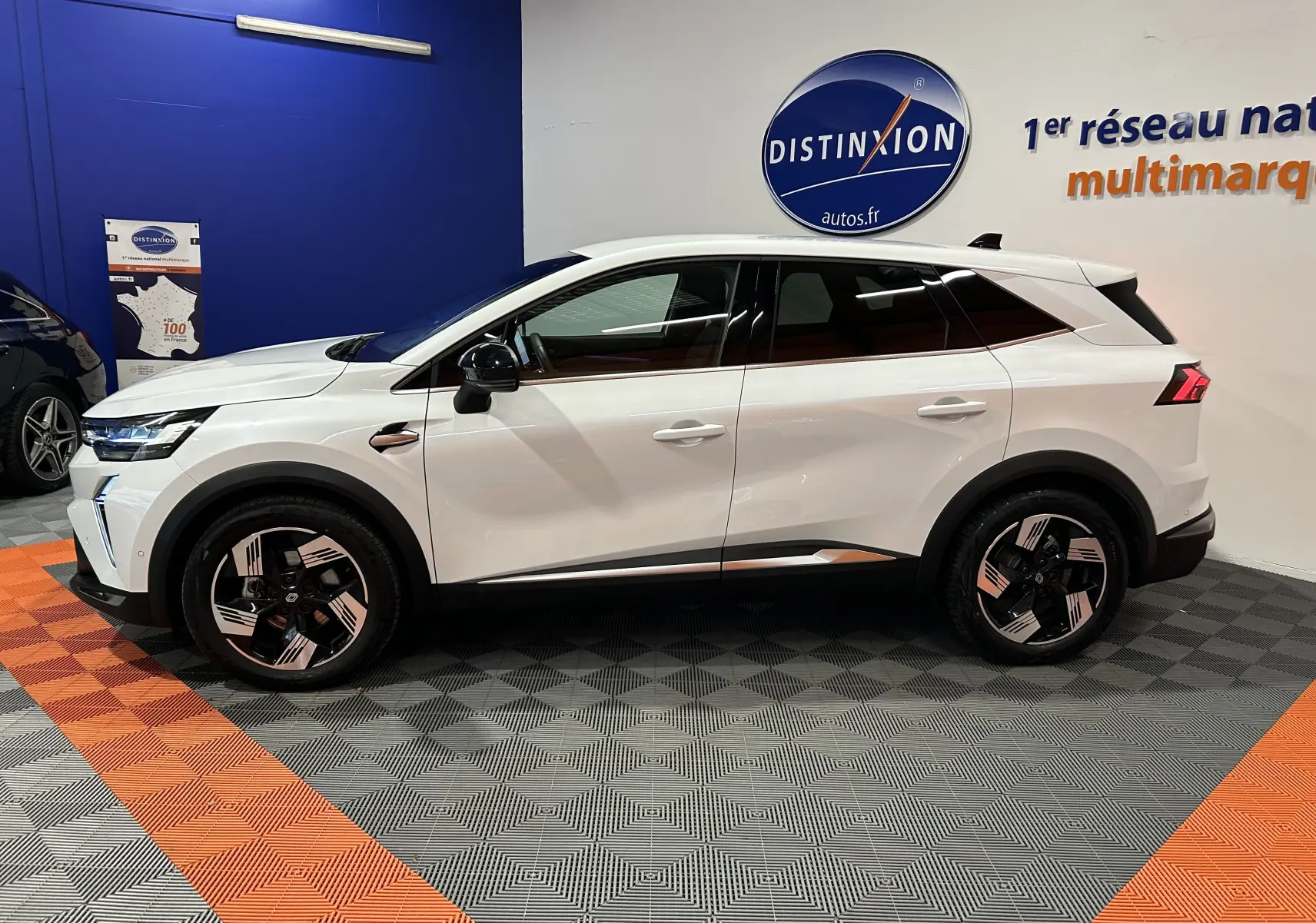 Profil latéral droit du Renault SYMBIOZ blanc nacré, SUV hybride 2025 avec jantes stylisées et vitres teintées.