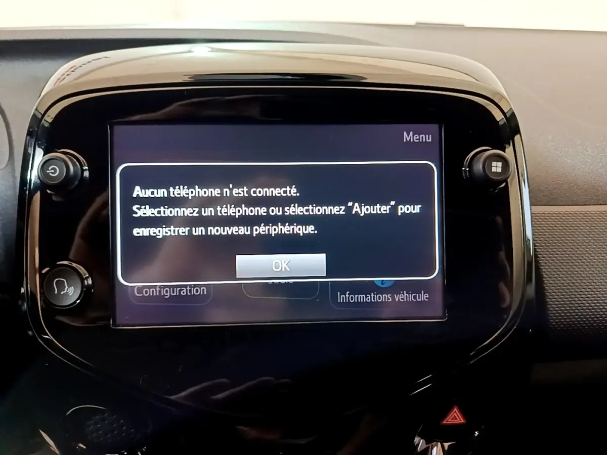 Écran tactile central de la Citroën C1 gris clair, affichant un message de connexion téléphone dans l'habitacle.