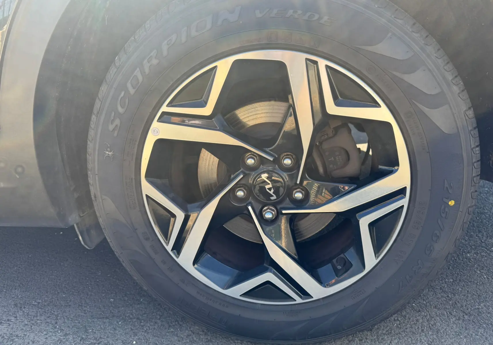 Gros plan sur la jante alliage noire et argentée du Kia Sportage 2022 avec logo Kia au centre et pneu Pirelli Scorpion Verde.