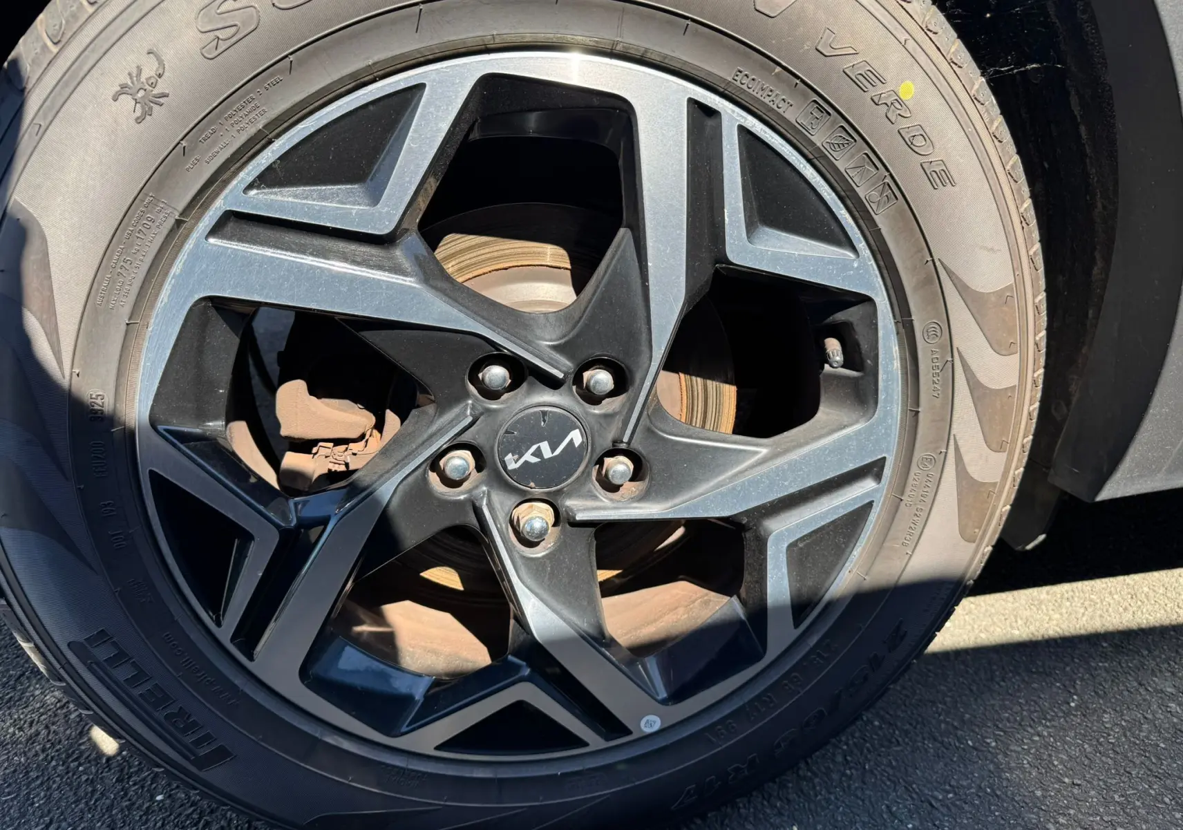 Gros plan sur la jante noire et grise du Kia Sportage 2022, mettant en valeur le logo central et le pneu Pirelli.