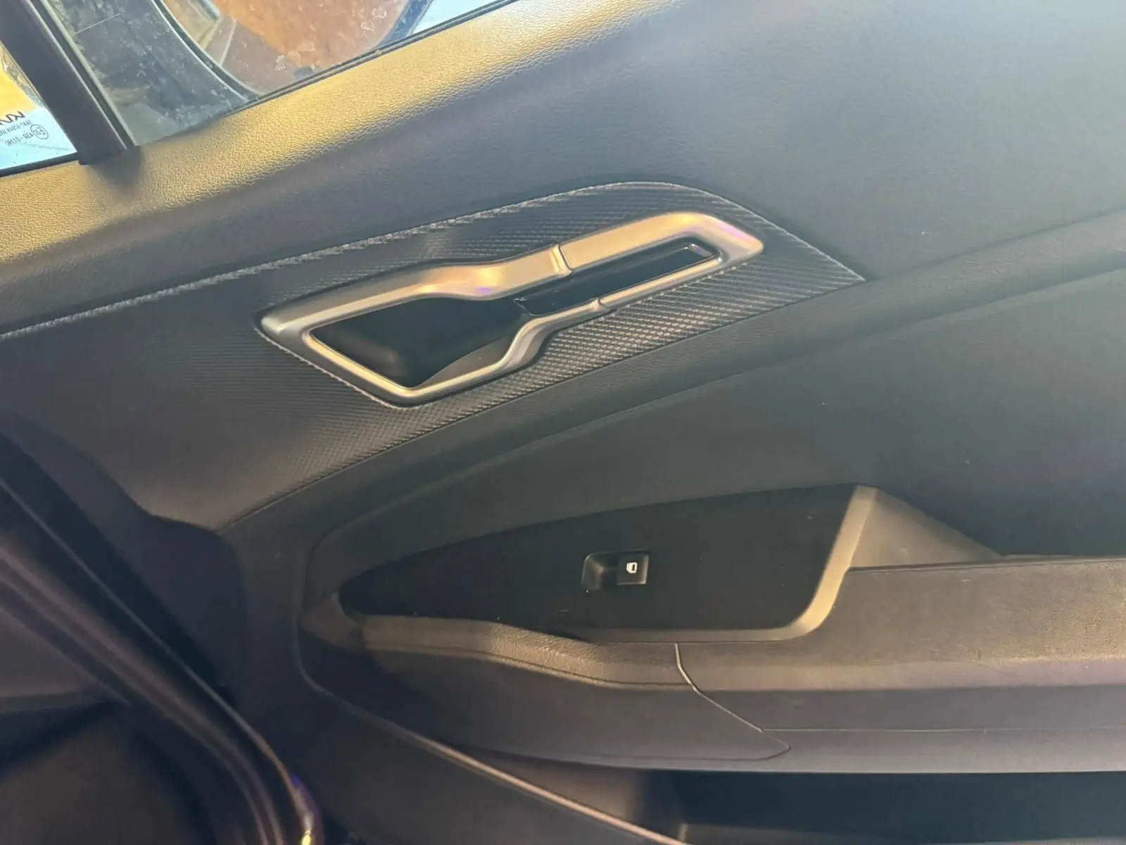 Détail de la poignée intérieure côté gauche noire du KIA SPORTAGE 2022 avec finition tissu et design moderne.