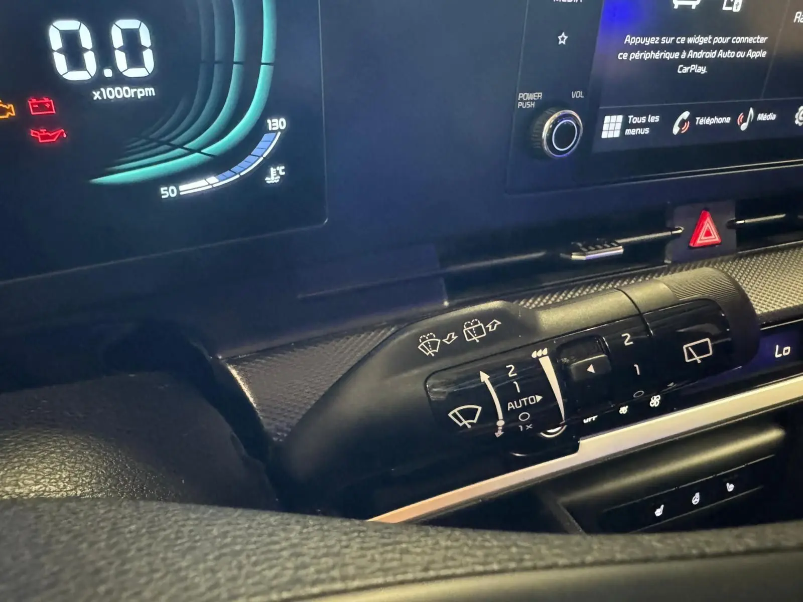 Détail du commodo d’essuie-glace côté droit du tableau de bord noir du Kia Sportage 2022 hybride diesel.