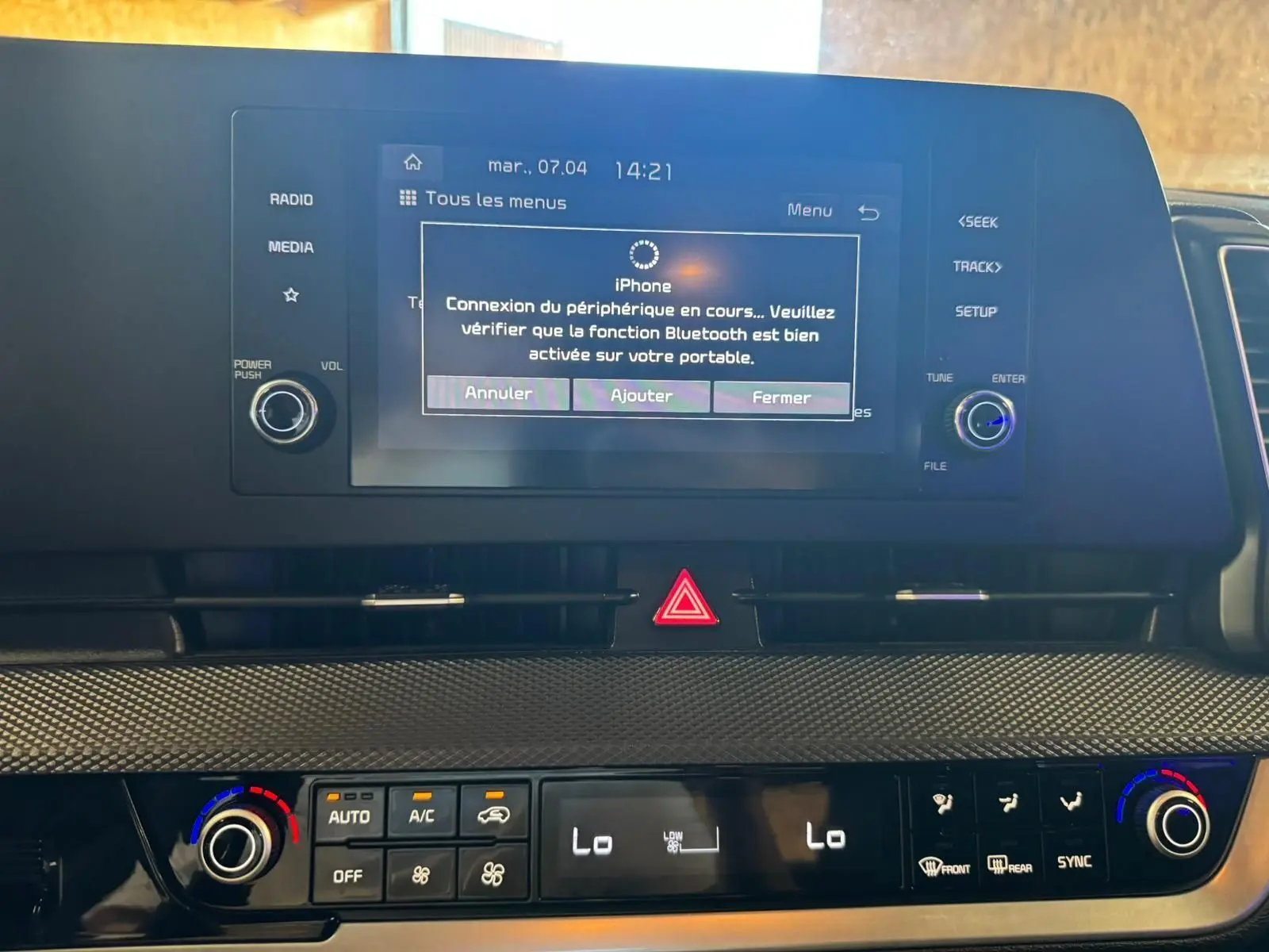 Tableau de bord intérieur du Kia Sportage 2022 avec écran tactile affichant connexion Bluetooth et commandes climatisation.