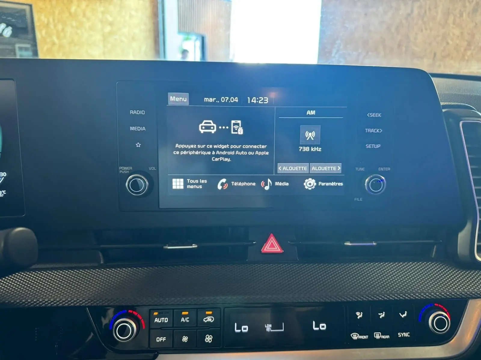 Vue rapprochée de l’écran tactile et de la console de climatisation du Kia Sportage noir 2022, intérieur moderne et fonctionnel.