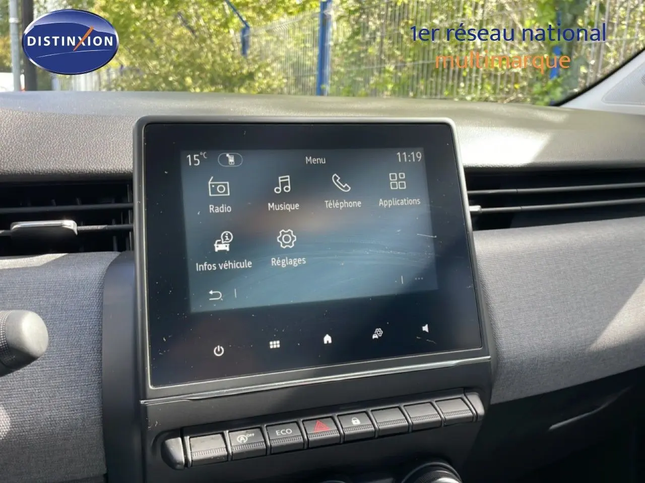 Vue intérieure centrée sur l’écran tactile multimédia de la Renault Clio gris schiste métal, avec commandes en dessous.