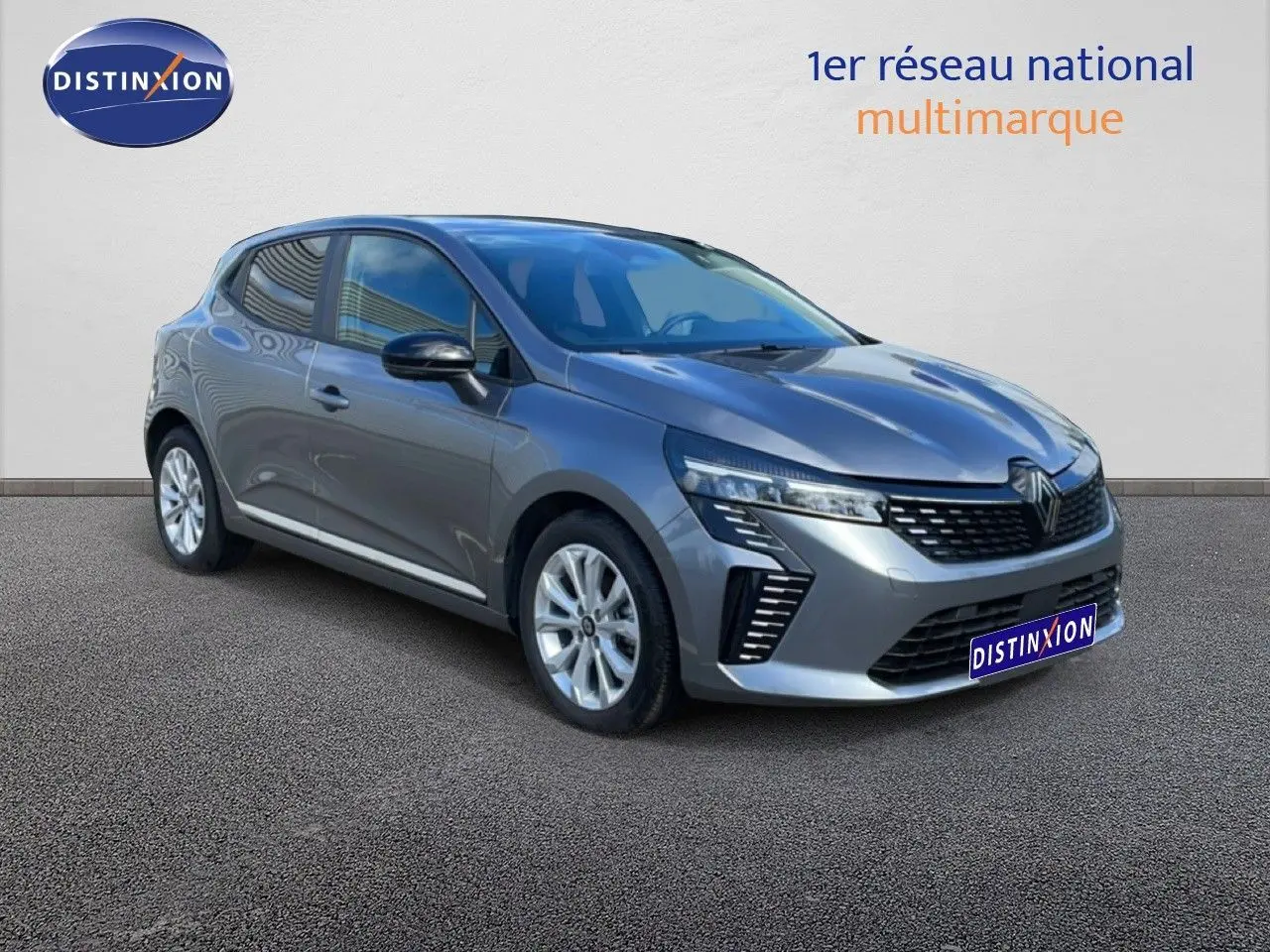 Renault Clio 2025 gris schiste métal en 3/4 avant droit, avec calandre moderne et feux LED distinctifs.