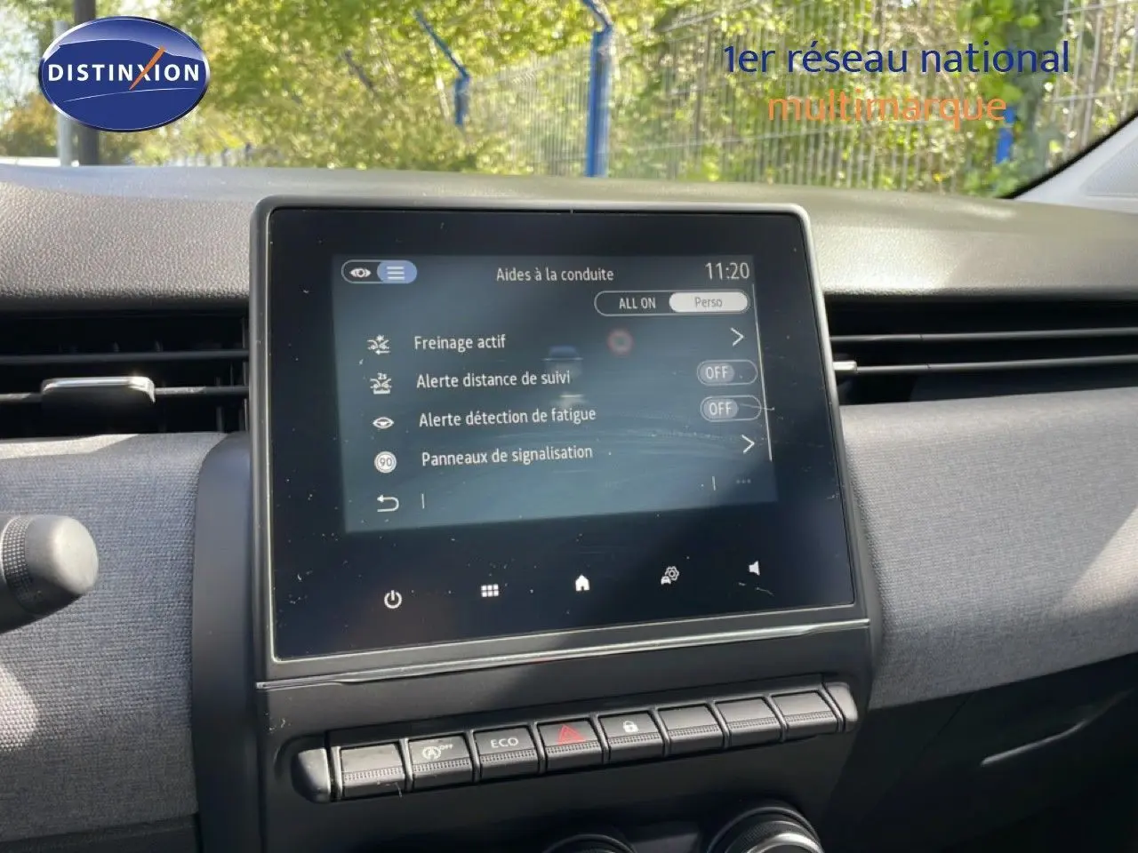 Vue rapprochée de l’écran tactile central du tableau de bord de la Renault Clio gris schiste métal, affichant les aides à la conduite.