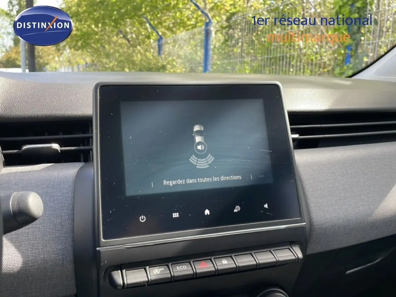 Vue rapprochée de l’écran tactile central de la Renault Clio 2025 avec tableau de bord gris et commandes en ligne.