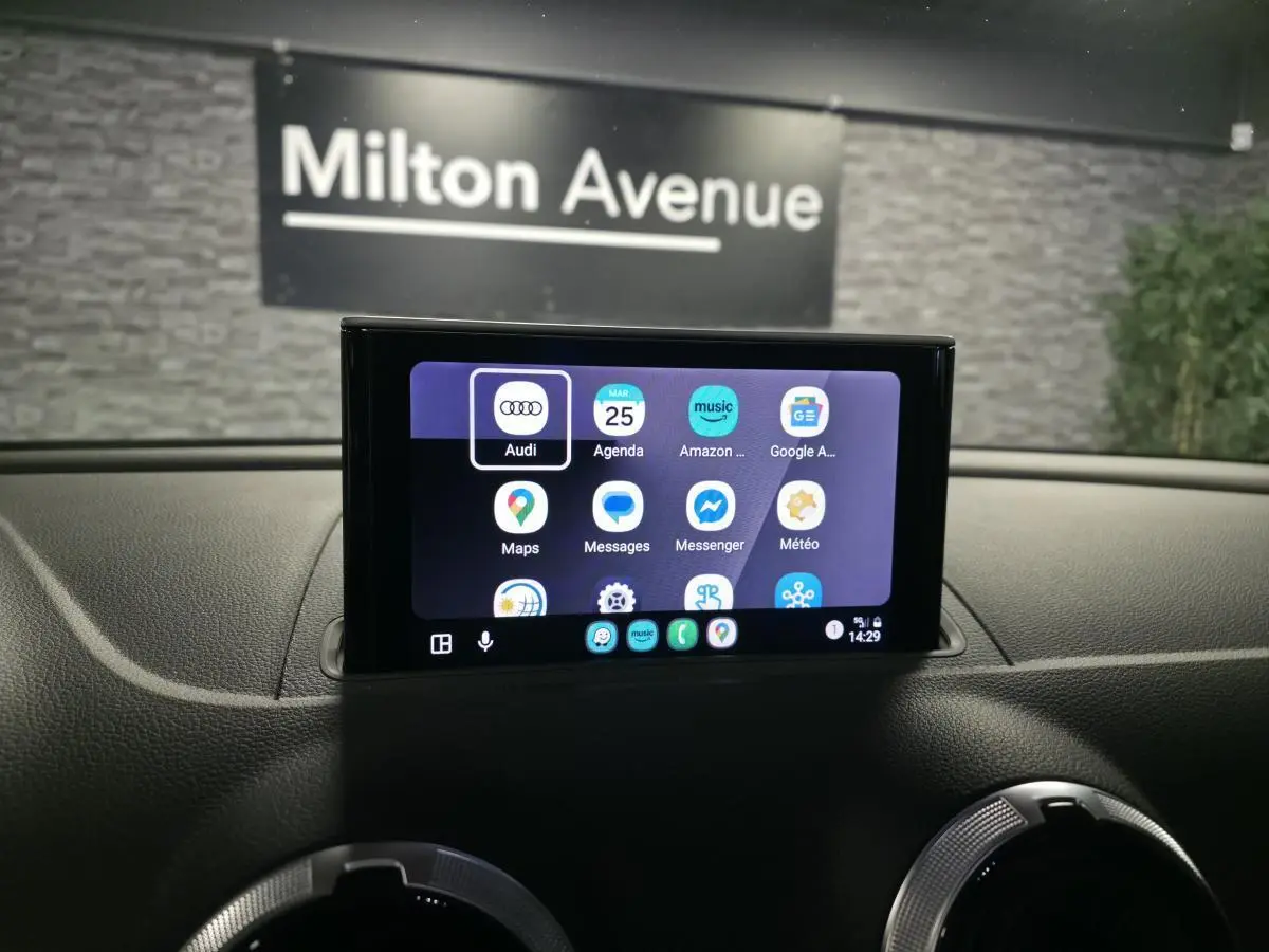 Écran tactile central de l’Audi A3 Sportback rouge, vue intérieure du tableau de bord avec interface connectée.